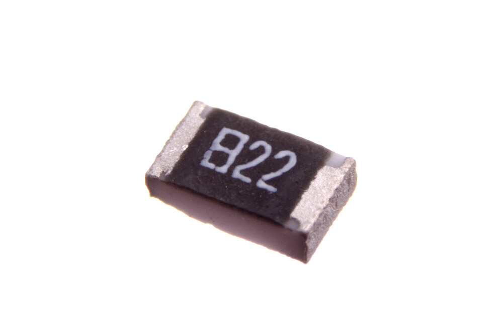 A tiny black rectangular 0805 SMD resistor with metal end-caps, marked 822, next to nothing for scale.