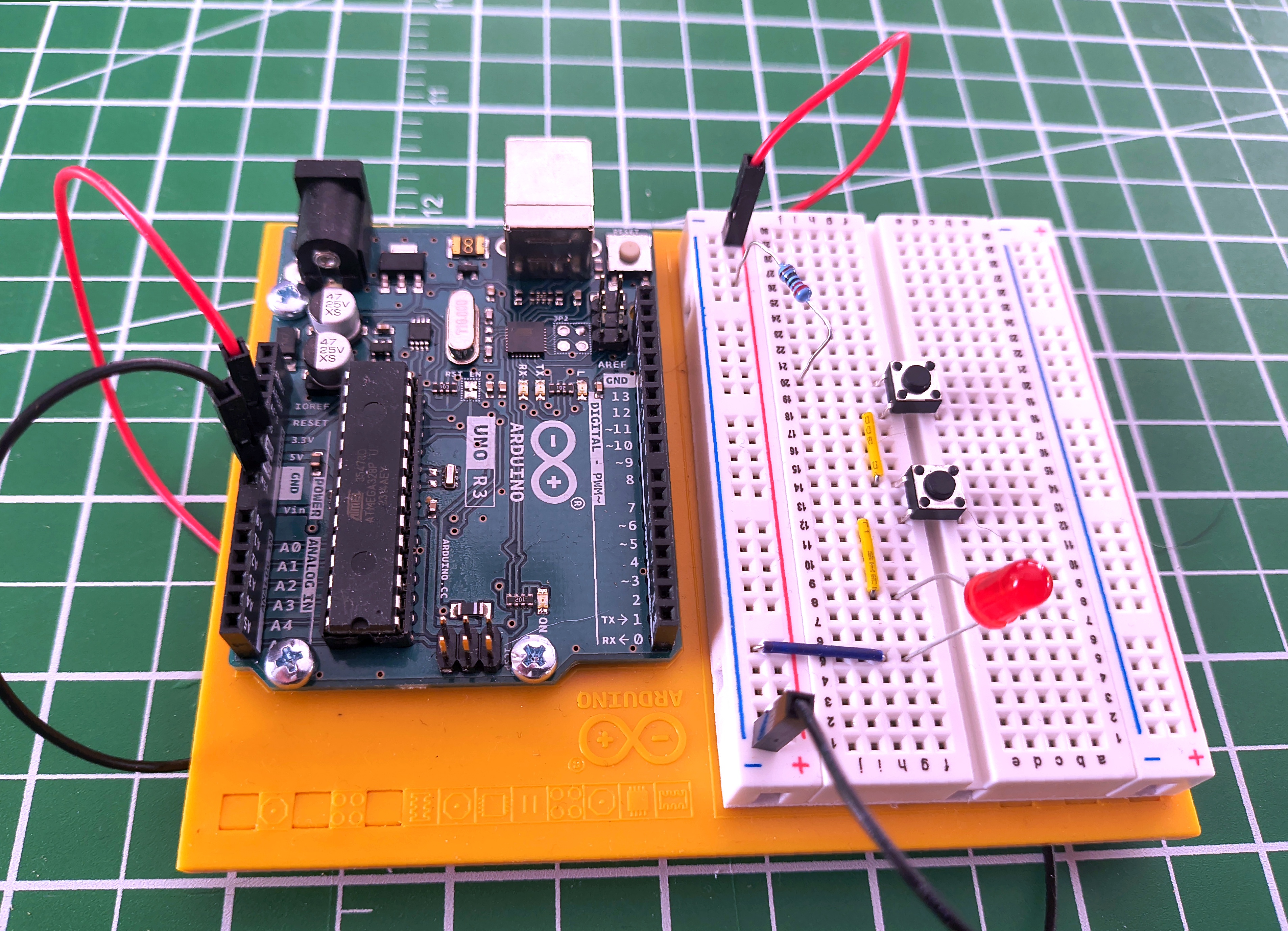 Two pushbutton switches wired in series with an LED. Both must be pressed simultaneously to light the LED.